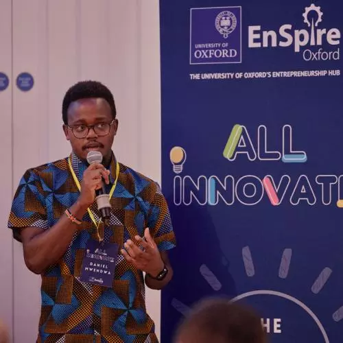 An early stage entrepreneur holding a microphone and pitching to an audience