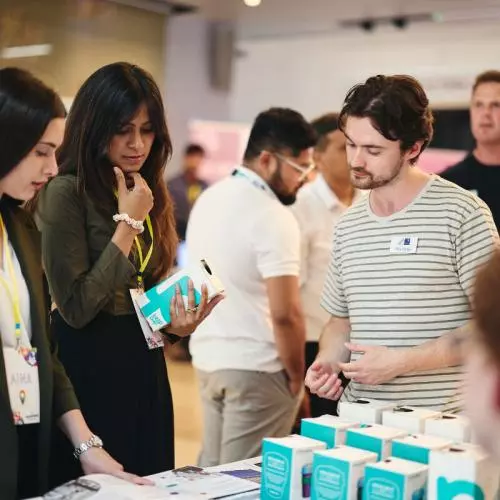 event attendees listening to a founder at their stand
