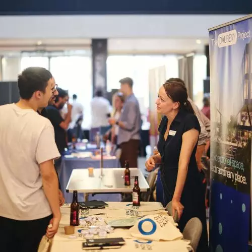 Two people talking at an exhibition stand