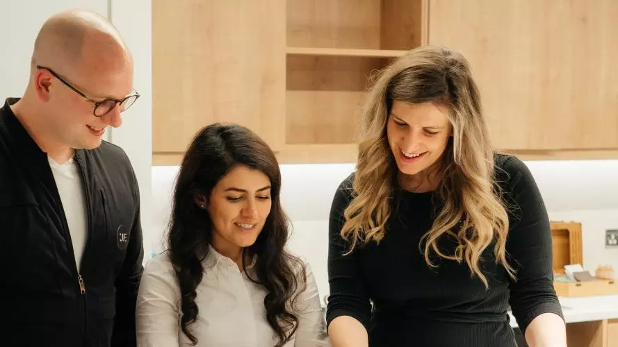 The Jack Fertility team stood around a table together looking at documents