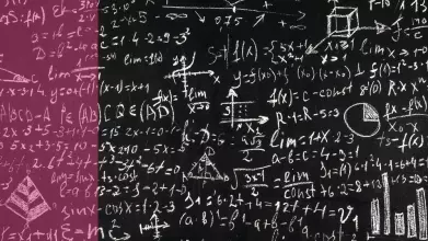 A chalkboard covered in maths calculations and diagrams