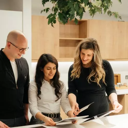 The Jack Fertility team stood around a table together looking at documents