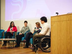 Four people talking on a stage in a panel discussion