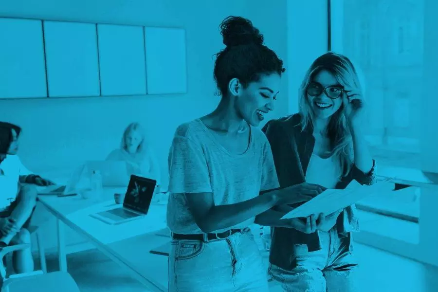 two women looking at a document together with a blue gradient overlay